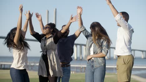 Slow-motion-shot-of-smiling-company-jumping-in-park.