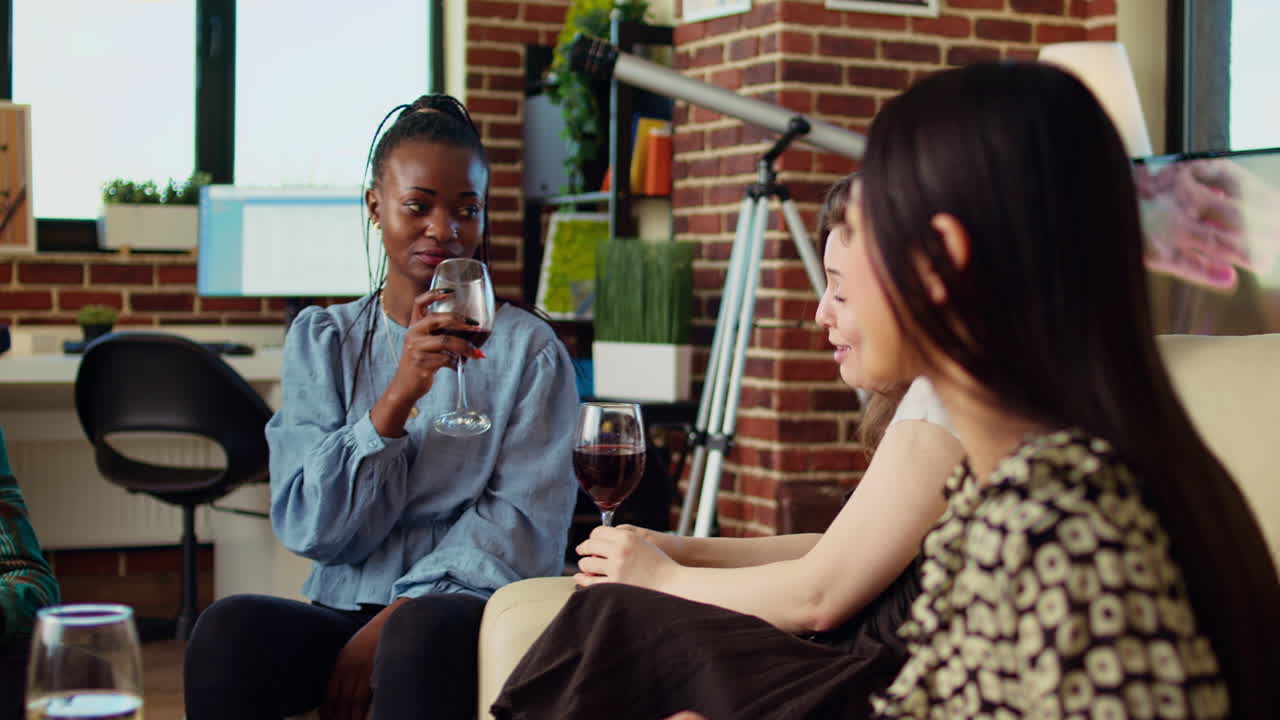 Women talking, drinking wine at reunion gathering, gossiping about their boyfriends