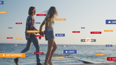 animación de texto e iconos de las redes sociales sobre una pareja caucásica en la playa