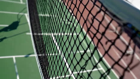 close-up of a tennis court net with the court in the background
