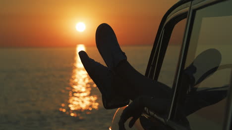 sunset road trip with legs out the window