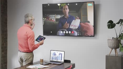 Caucasian-businessman-on-video-call-with-african-american-male-colleague-on-tv-screen