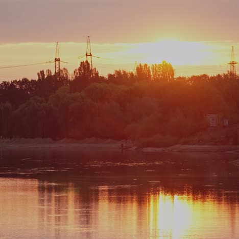 beautiful sunset above trees and river. evening sky reflection on water. countryside scene. rural landscape