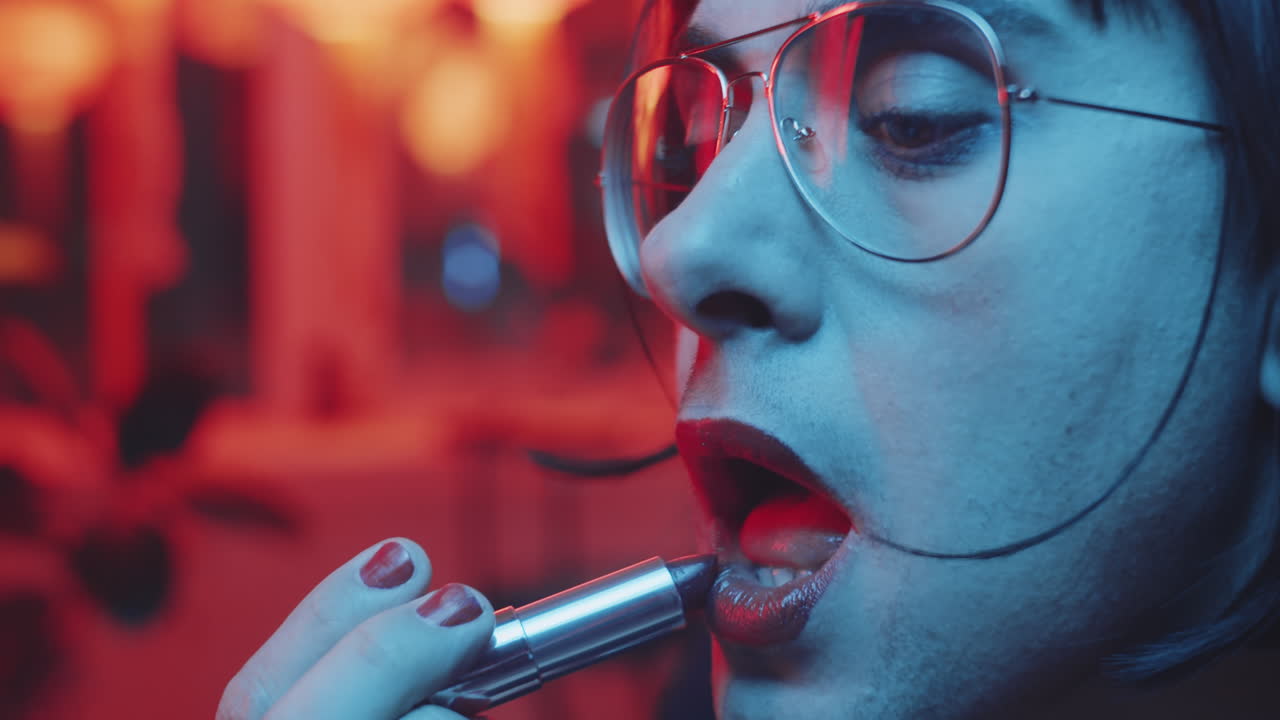 hombre transgénero poniéndose lápiz labial en un bar