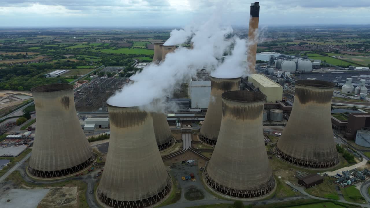Cinematic drone pass showing cooling towers, stacks and substation yards at a large power complex Selby UK