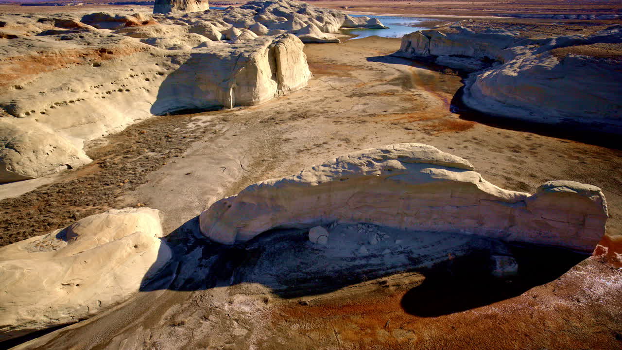 Aerial drone footage sweeping toward eye-catching rock formations near Lake Powell in Page, Arizona.