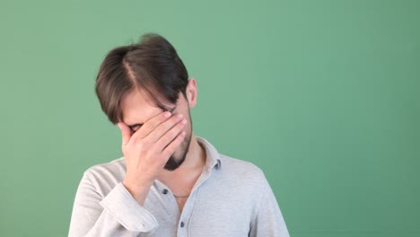man unhappy green background