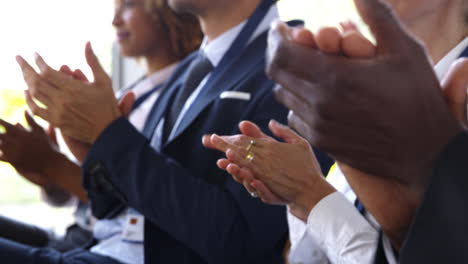 close up of delegates at business conference applauding speaker