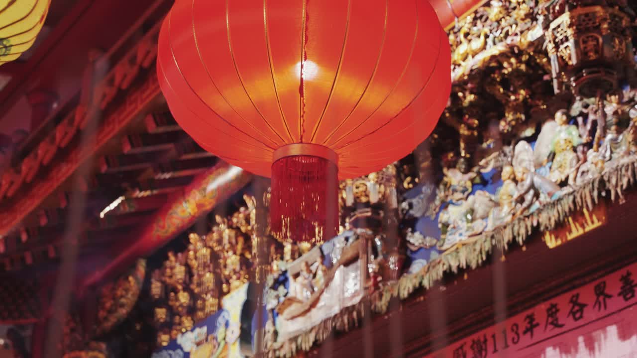 Glowing red Chinese lantern hangs above incense candles at a Taiwanese temple, creating a serene and spiritual atmosphere rich with tradition