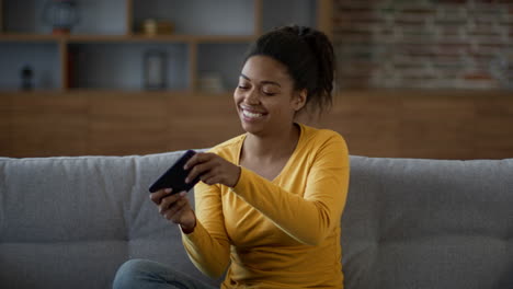 woman using a phone on a couch