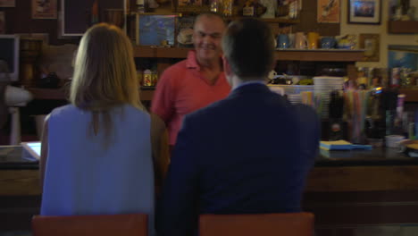 barman serving cocktails to the couple