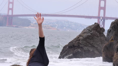 Interpretive-Dancing-in-Front-of-Golden-Gate-Bridge,-Foggy-Beach-in-SF