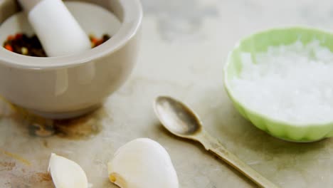 black pepper in mortar and pestle with bowl of salt and garlic 4k