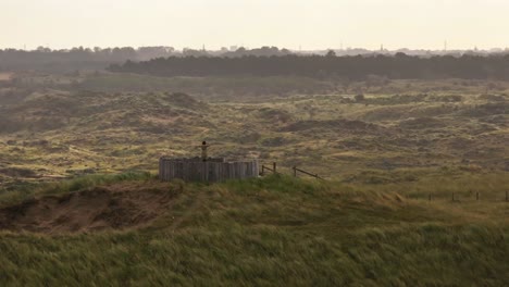 person standing on a wooden structure amidst dunes