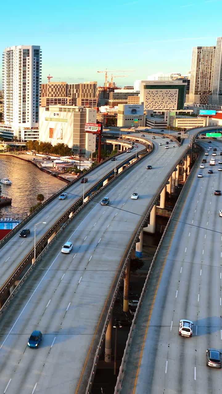 Flying above the highways and cars running by. Lovely view of sunny Miami in Florida, USA. Vertical video