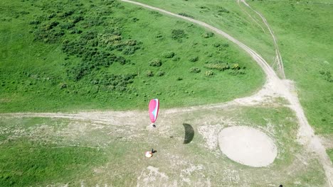 paragliding in the mountains. green fields, hills