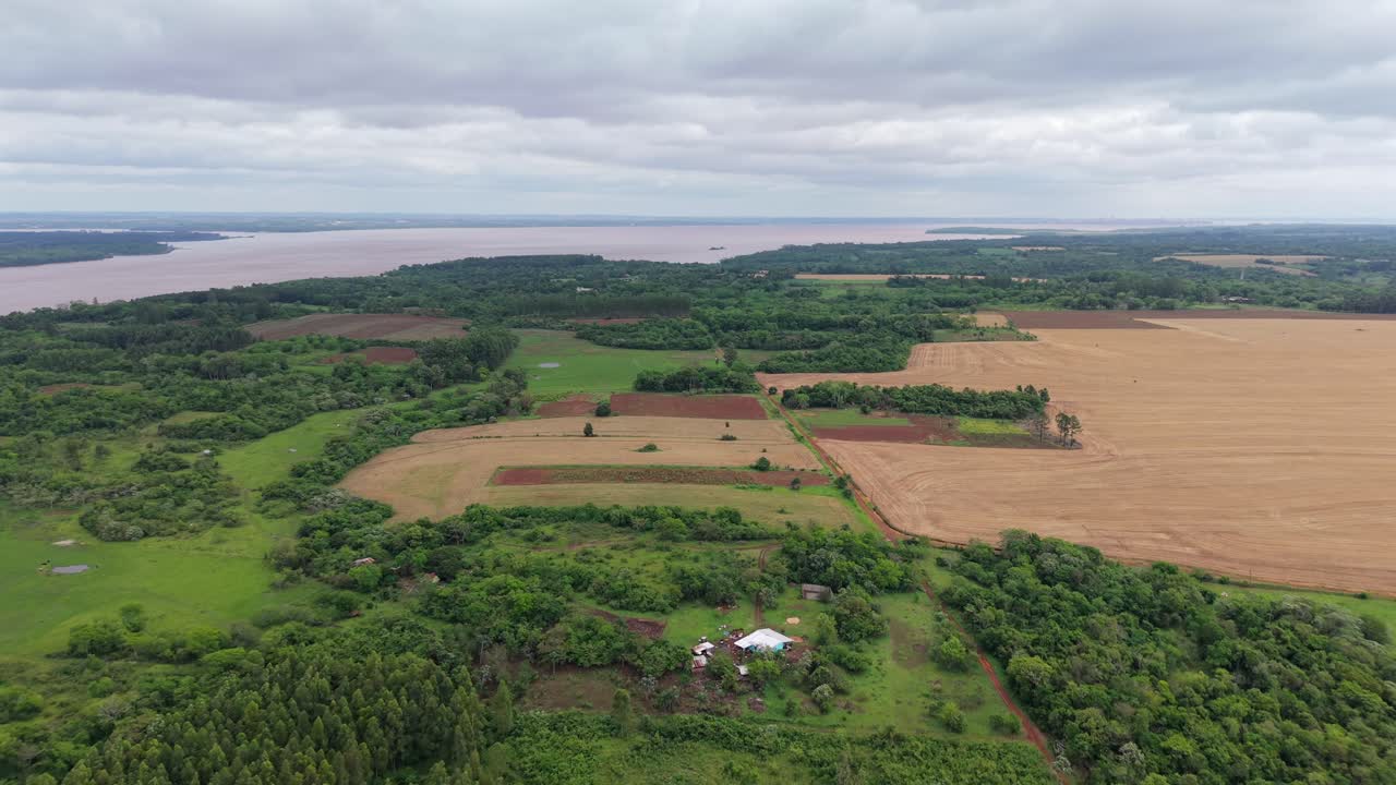 Aerial view of agricultural fields, plantations, and green forest patches on open terrains, Campichuelo, Salta, Paraguay