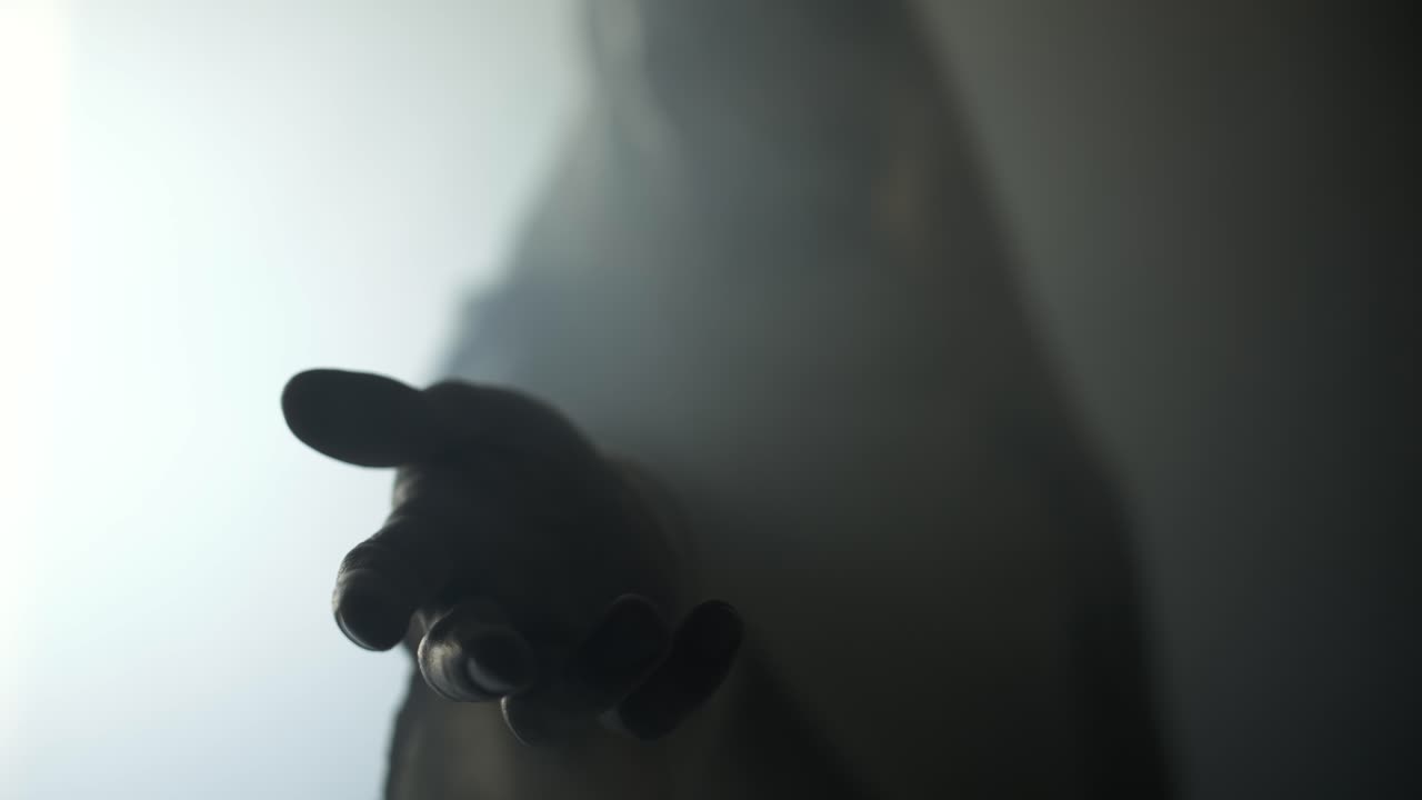 Jesus Christ in glowing, abstract, bright light, offering his hand for help, salvation, love, forgiveness. Cinematic, slow motion Christian visual representation of Easter resurrection and the gospel.