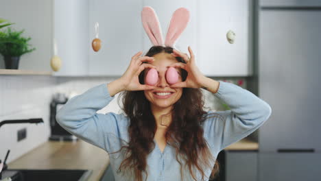 woman with bunny ears and pink eggs in kitchen