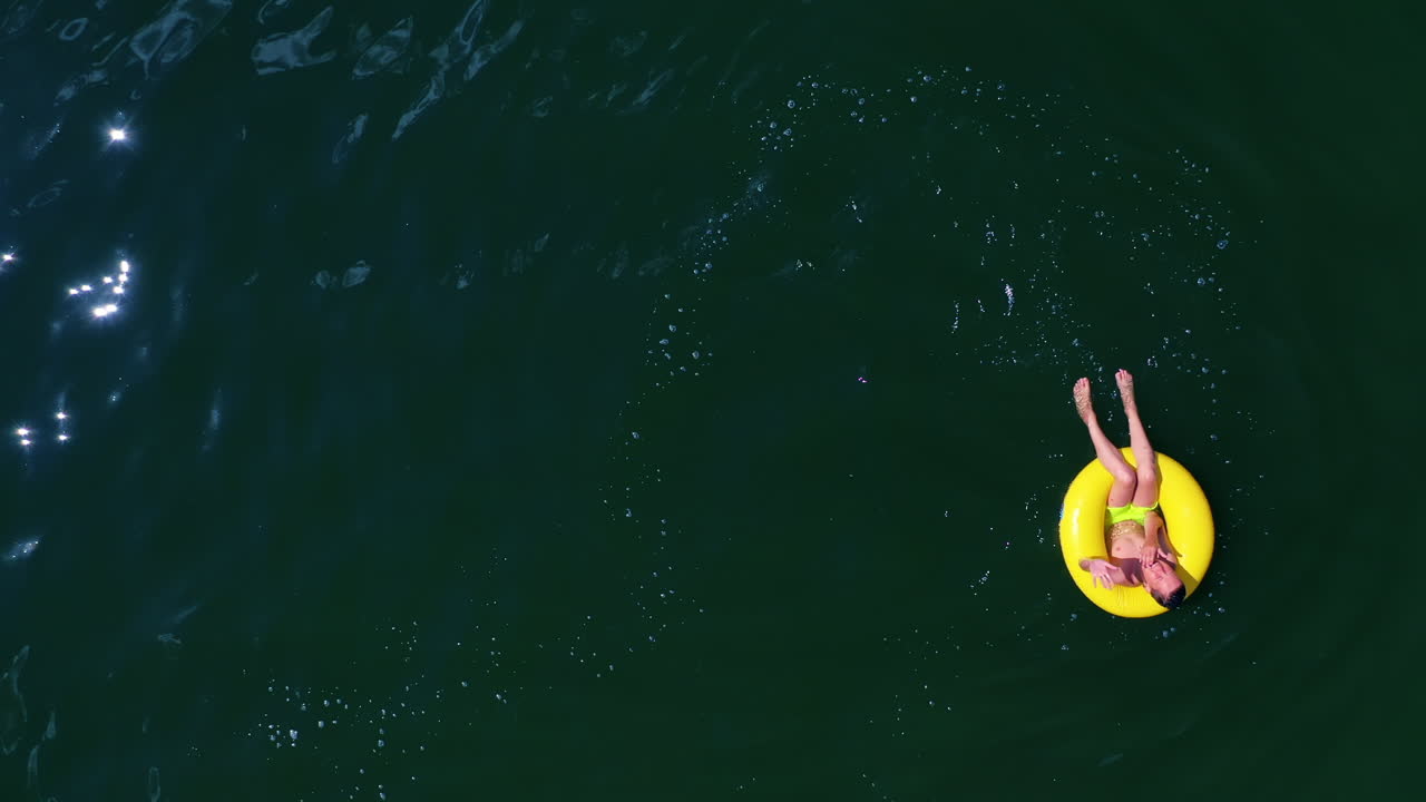 Boy with inflatable swim ring. Top down view of boy swimming with rubber ring