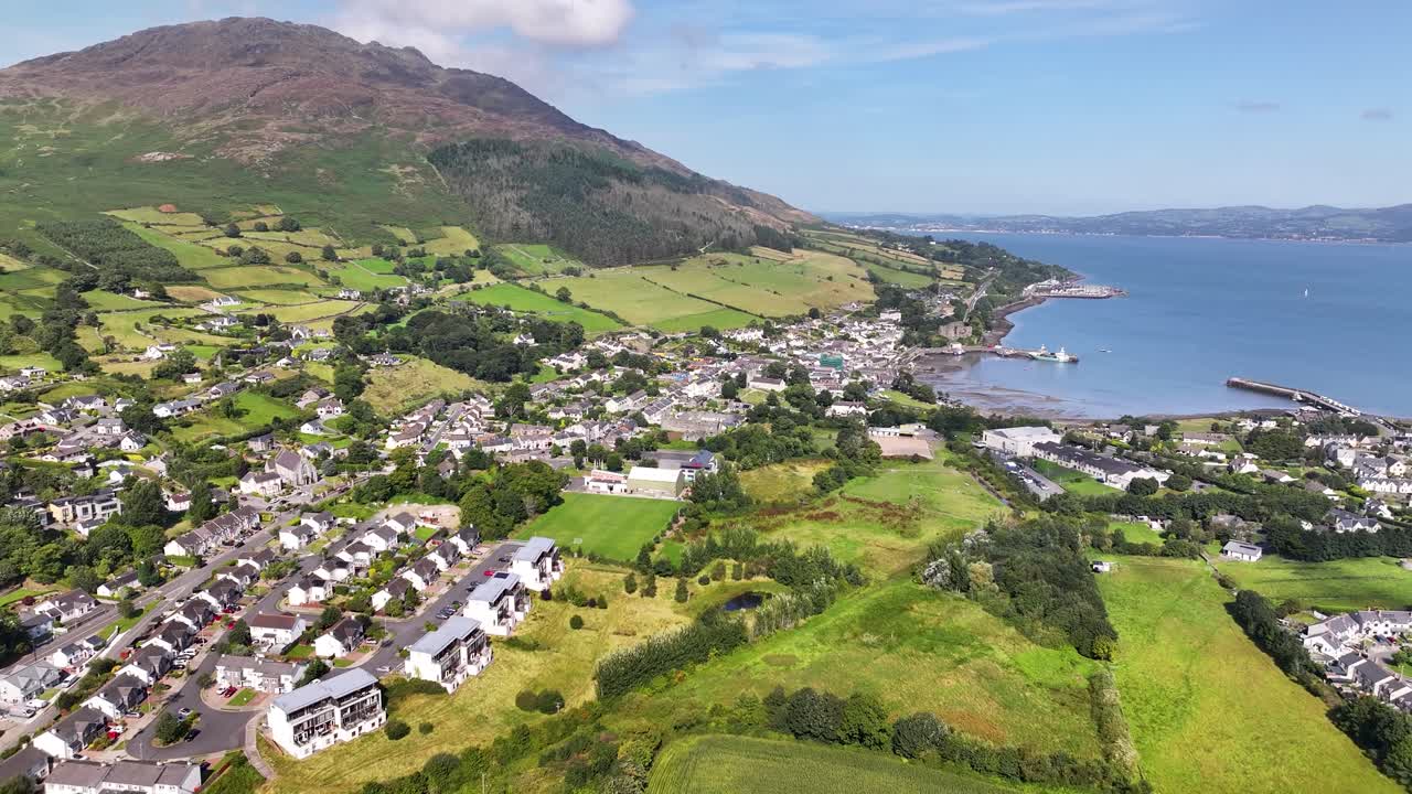 Carlingford, Ireland - aerial establish shot of picturesque small town on coast, sunny day