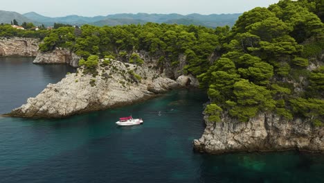 kalamota island, adriatic sea, croatia - a sailboat gently sailing near the steep and rugged cliffs - aerial drone shot