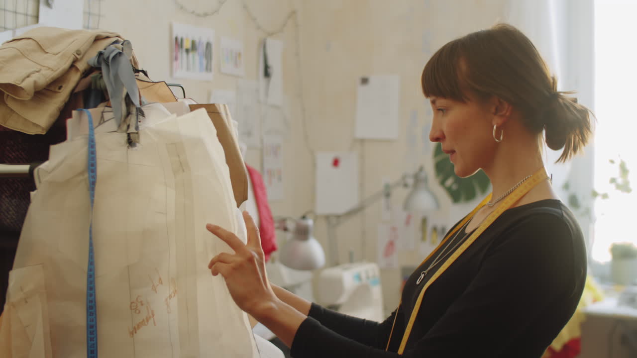 Female Dressmaker Choosing Sewing Patterns