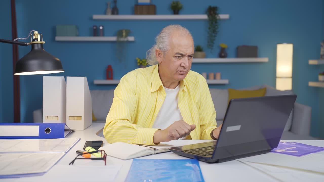 Home office worker old man nervously waiting at laptop.