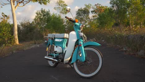 vintage turquoise and white scooter on a scenic road