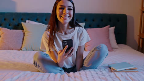 mujer usando teléfono inteligente en la cama