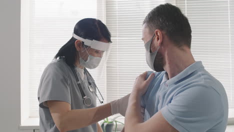 nurse giving vaccination dose to patient
