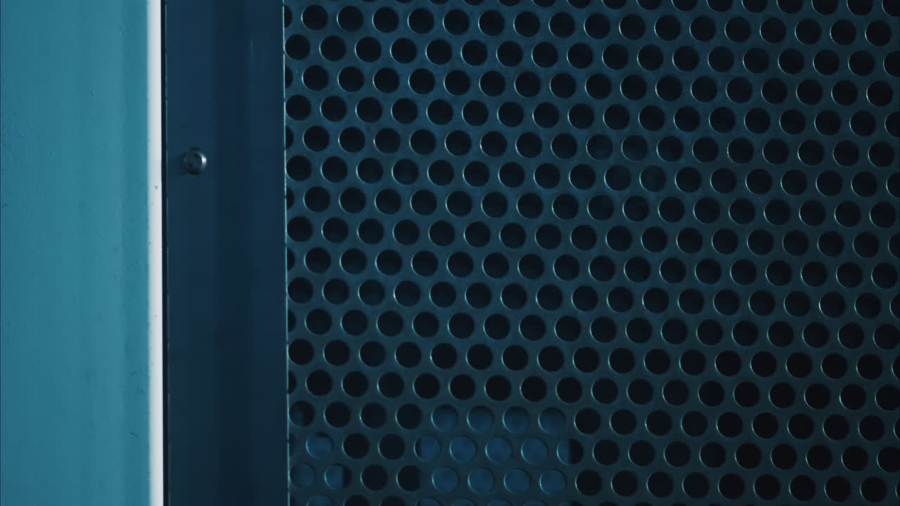 Close-up view of a perforated surface of a vent, with circular holes