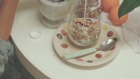 cozy breakfast setup, pouring fresh milk on a glass of overnight oat with nuts and raisins showing a relaxing and healthy morning routine