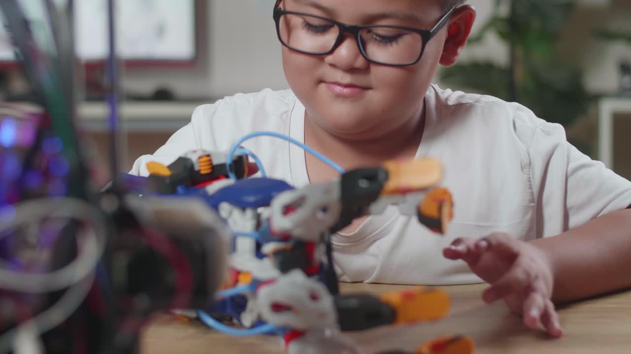 primer plano de un chico asiático bonito comprobando una mano de cyborg en casa