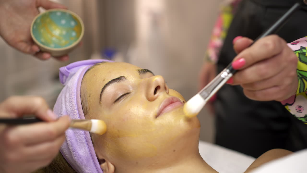 Woman receiving a facial mask treatment at a beauty salon