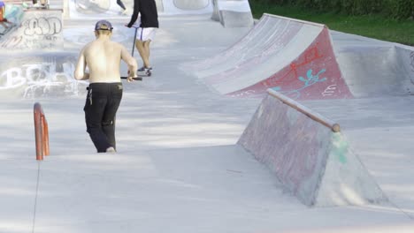 kids scootering and skateboarding at a skatepark