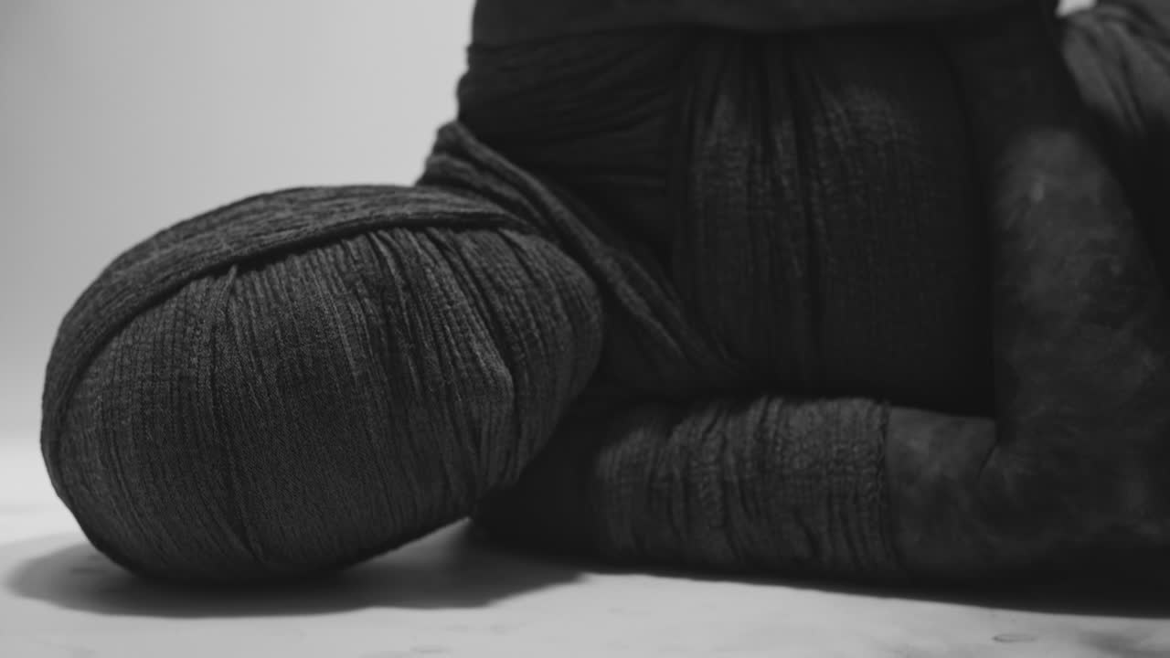 A mummy of a woman lying on the white backdrop