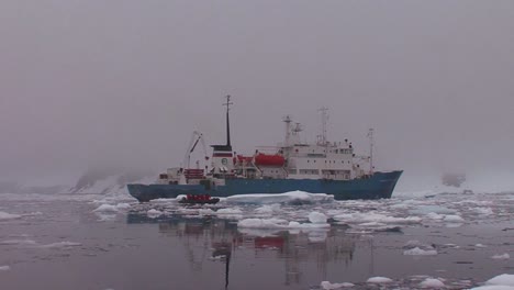 an oceanic research vessel floats amongst icebergs in antarctica