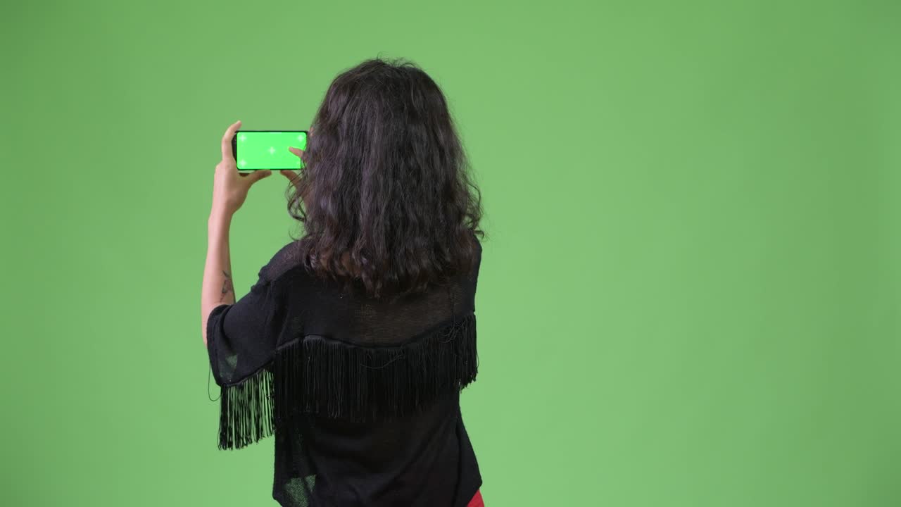Young beautiful woman taking picture with phone