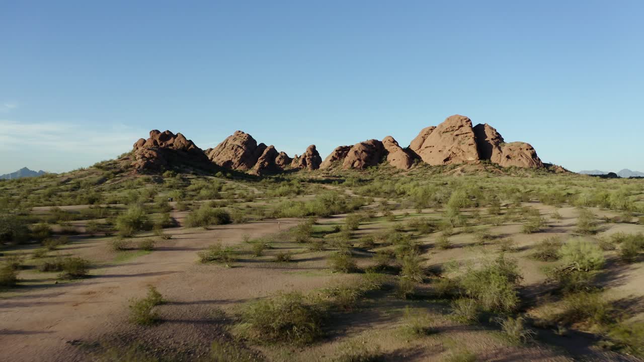 Drone shot pulling away from a rock formation in Arizona's desert landscape.
