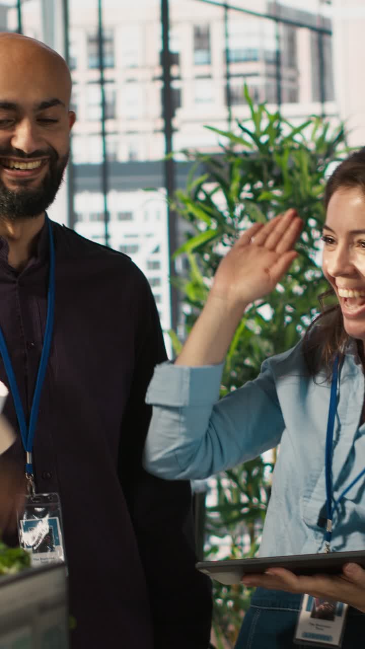 Vertical video Relaxed coworkers in office having fun chatting while reviewing documents
