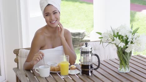 Grinning-woman-at-breakfast-table-outdoors