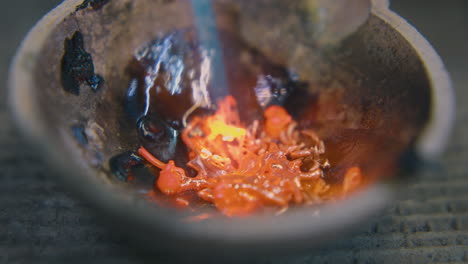 derritiendo oro viejo en taza con quemador de gas caliente en el primer plano de la mesa