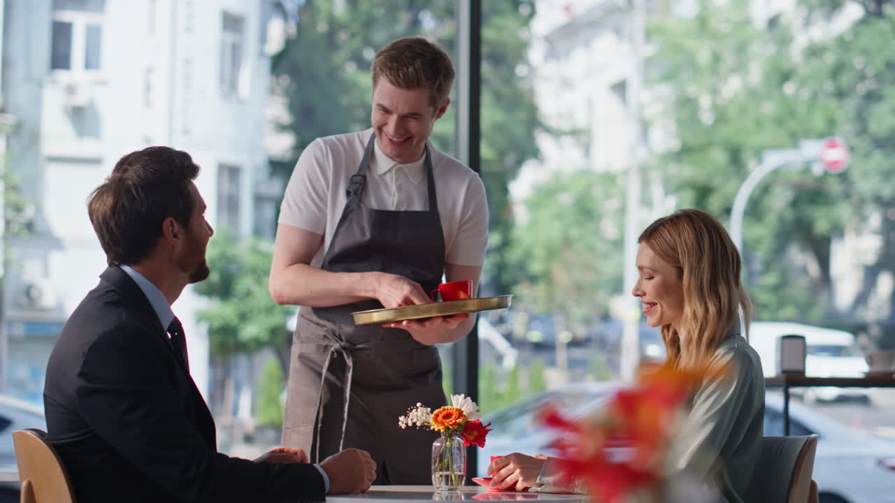Business colleagues meeting cafe. Friendly waiter bringing coffee to clients