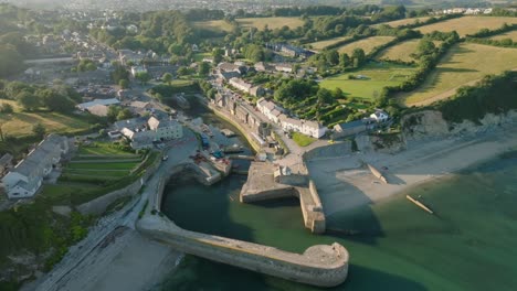quaint harbour village with camera reverse revealing port walls and clear blue sea. charlestown, cornwall, uk.