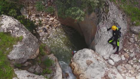 climbers rappelling down waterfall