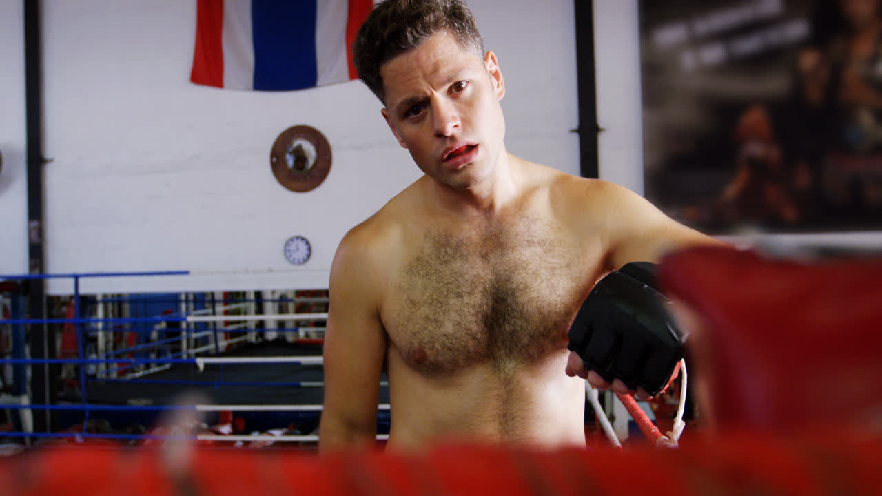 피곤 한 남자 권투 선수 가 링 에 서 있다