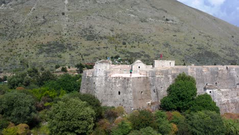 Aerial-view-of-a-person-standing-on-top-of-Ali-Pasha-Castle-in-Porto-Palermo-bay,-Albania