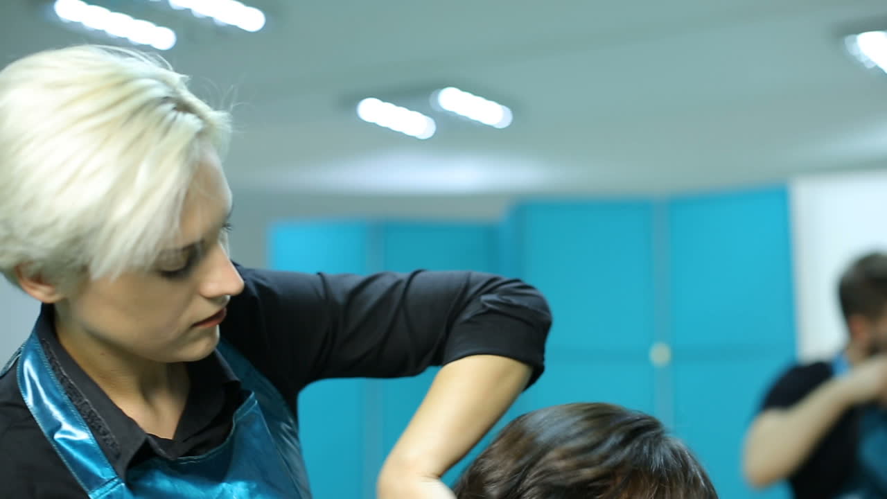 Professional hair care. Woman cutting her hair in hairdresser salon