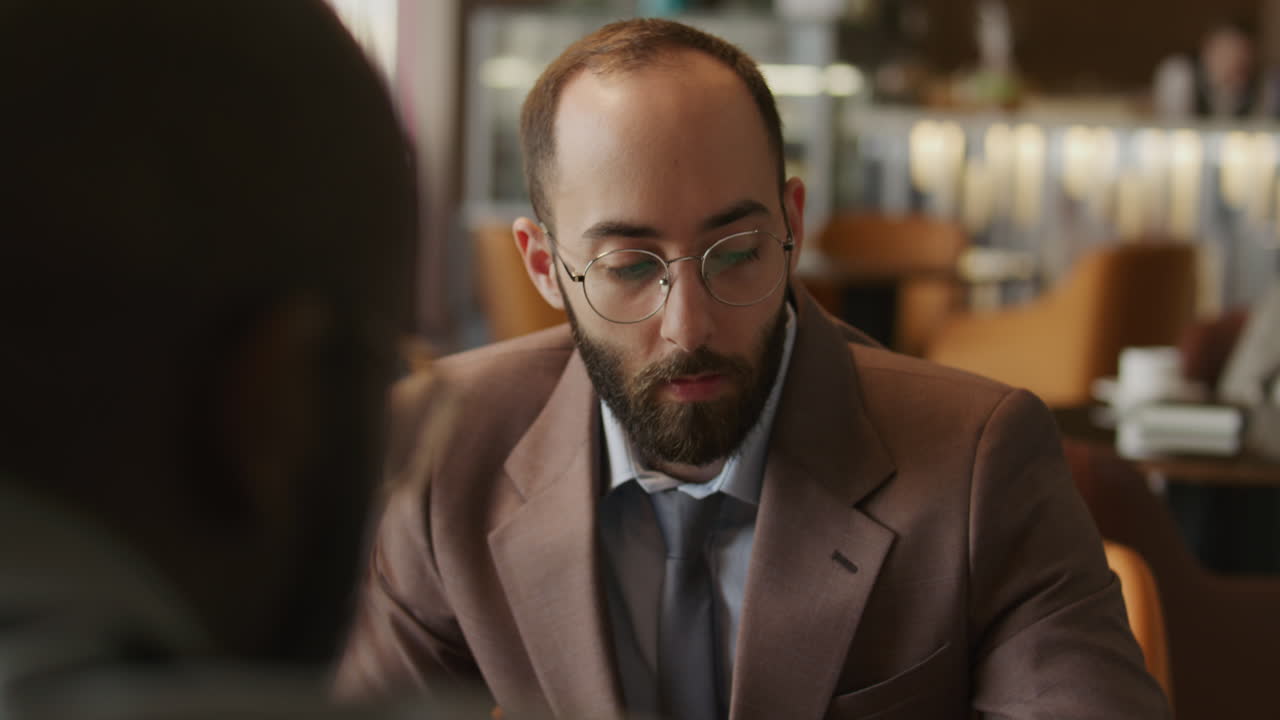 Man Shaking Hands and Discussing Financial Document with Business Partner
